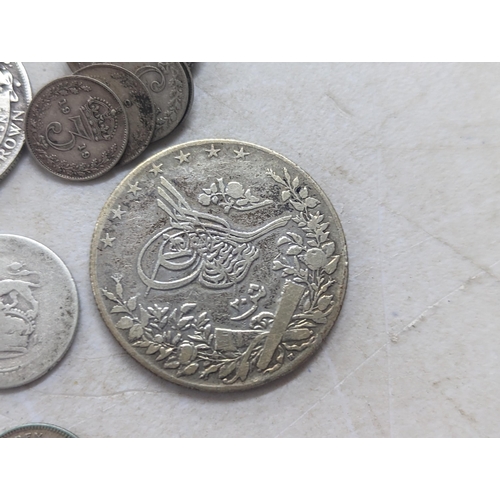 322 - A mixed group of early 20th century coins to include a 1935 Canadian silver Dollar, Egyptian 20-Qirs... 