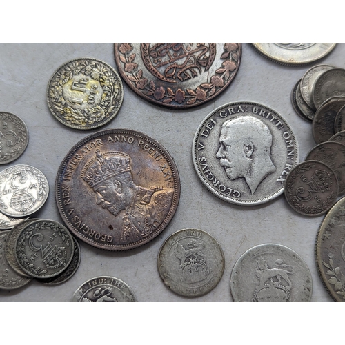 322 - A mixed group of early 20th century coins to include a 1935 Canadian silver Dollar, Egyptian 20-Qirs... 