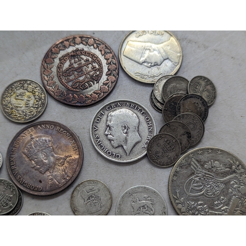 322 - A mixed group of early 20th century coins to include a 1935 Canadian silver Dollar, Egyptian 20-Qirs... 