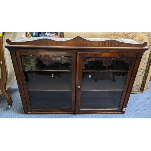 33 - A 19th century mahogany two door glazed wall hanging cabinet, having carved fretwork and two loose s... 