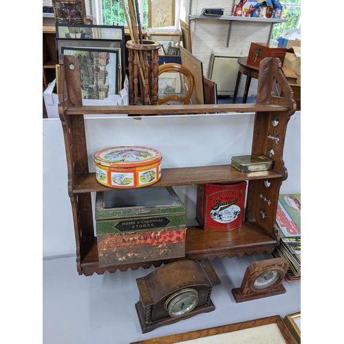 366 - A mixed lot to include an oak wall hanging shelf, vintage tins, two clocks, framed pictures and clas... 