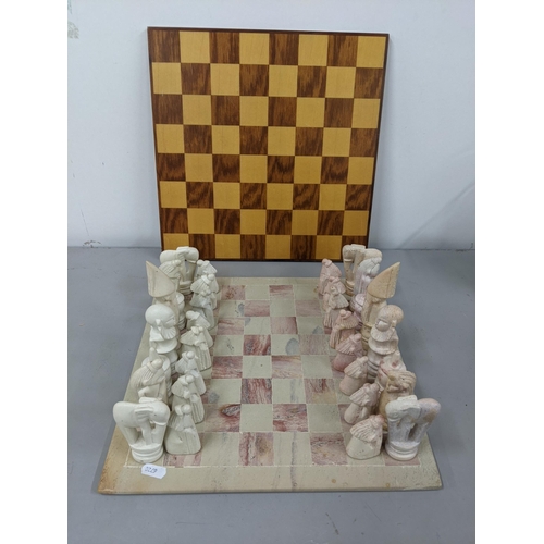 41 - A soapstone chess board having engraved chess pieces, along with a wooden chessboard Location:1.2