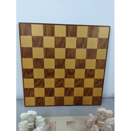 41 - A soapstone chess board having engraved chess pieces, along with a wooden chessboard Location:1.2