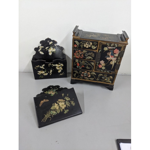 43 - Black lacquered papiermache comprising a pair of wall pockets, and a table top cabinet Location:10.3