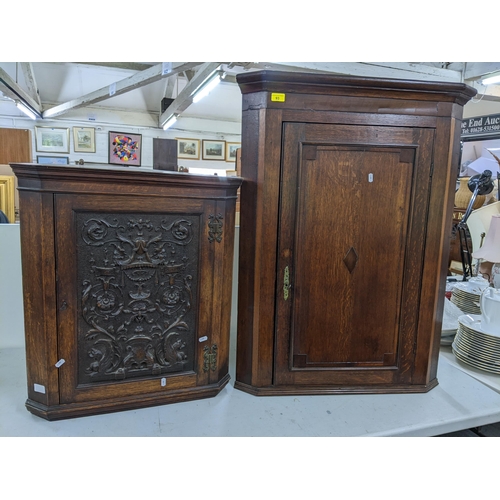 93 - A Georgian oak corner cabinet, together with an early 20th century oak corner cabinet having a carve... 