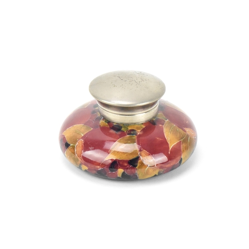 33 - A Moorcroft pottery capstan inkwell by William Moorcroft (1872-1945), in the 'pomegranate' pattern, ... 