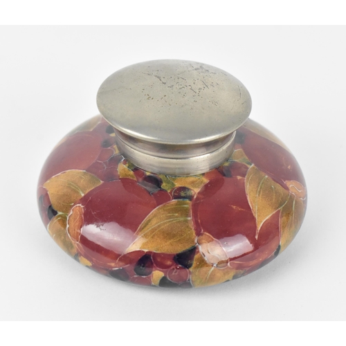 33 - A Moorcroft pottery capstan inkwell by William Moorcroft (1872-1945), in the 'pomegranate' pattern, ... 