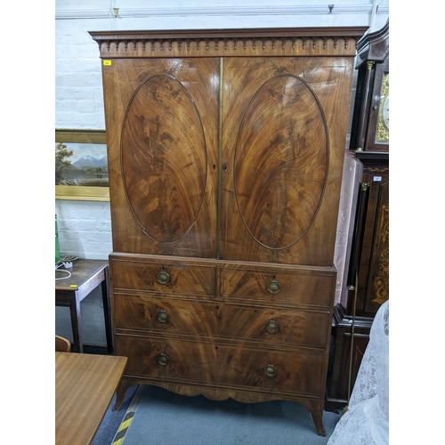 354 - An early 19th century mahogany wardrobe converted from a secretaire having two cupboard doors above ... 