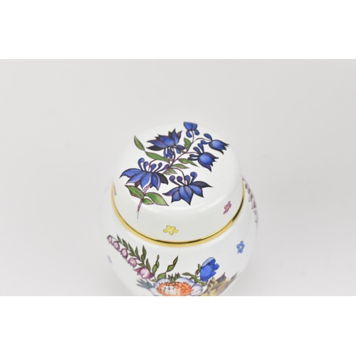 73 - A Moorcroft enamels miniature lidded vase, designed with floral sprays on a white ground with gilt r... 