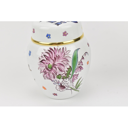 73 - A Moorcroft enamels miniature lidded vase, designed with floral sprays on a white ground with gilt r... 