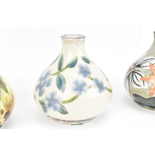 127 - A collection of five Cobridge ceramic bud vases, with various floral and fruit patterns, each with i... 