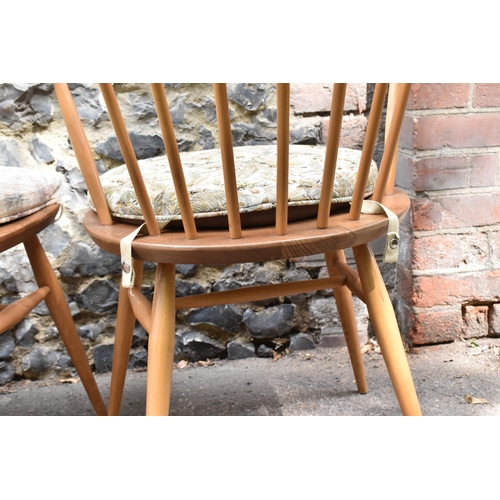 151 - A mid century light elm Ercol dining table and chairs, the table of rectangular form with tapering l... 