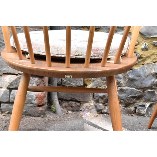 151 - A mid century light elm Ercol dining table and chairs, the table of rectangular form with tapering l... 