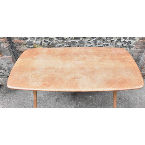 151 - A mid century light elm Ercol dining table and chairs, the table of rectangular form with tapering l... 