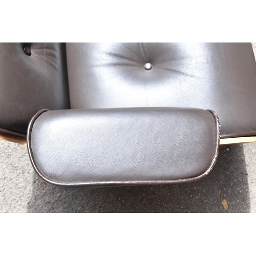 162 - A vintage brown leather armchair and ottoman, after the design by Charles and Ray Eames for Herman M... 