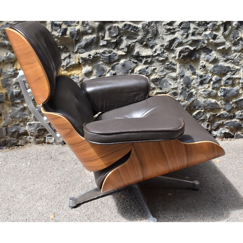 162 - A vintage brown leather armchair and ottoman, after the design by Charles and Ray Eames for Herman M... 