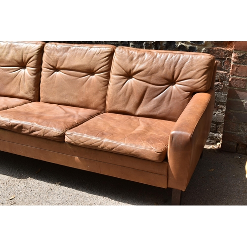 166 - A mid century design three-seater brown leather sofa, in the style of Georg Thams, with buttoned bac... 