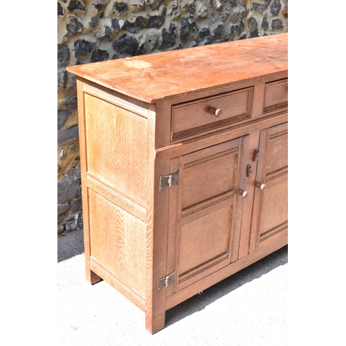 168 - A Heals limed oak sideboard, circa late 1930s, designed with forged iron exposed cabinet door hinges... 