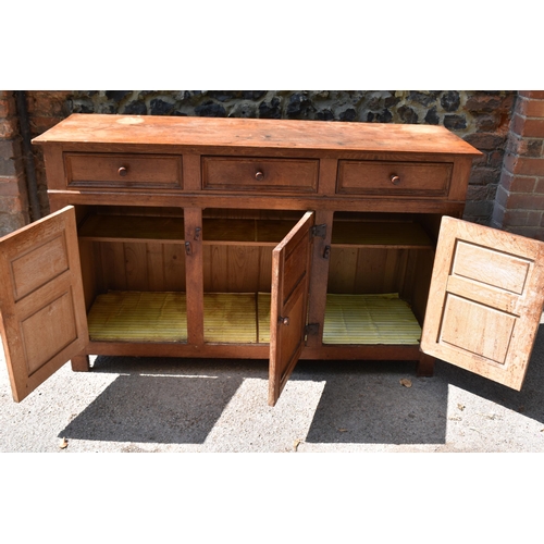 168 - A Heals limed oak sideboard, circa late 1930s, designed with forged iron exposed cabinet door hinges... 