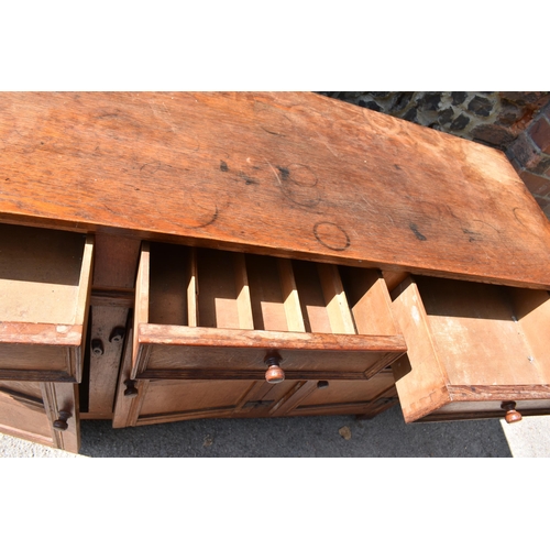 168 - A Heals limed oak sideboard, circa late 1930s, designed with forged iron exposed cabinet door hinges... 