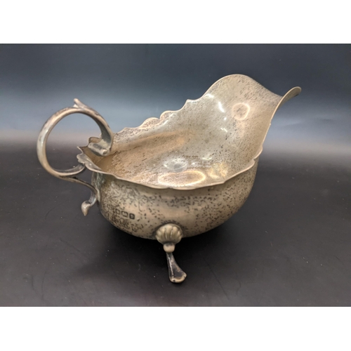 33 - An early 20th century silver sauce boat, having a wavy rim and on three splayed feet, 94.8g
Location... 