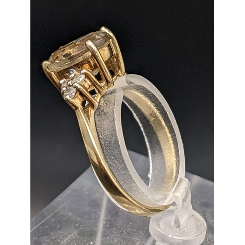 77 - THIS LOT IS WITHDRAWN
A 9ct gold yellow topaz oval cut ring flanked by three diamonds to each should... 