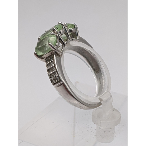 82 - THIS LOT IS WITHDRAWN
An 18ct white gold three-stone peridot ring with diamond set shoulders 3.5g Lo... 