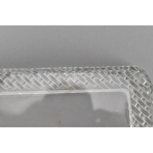 106 - A Lalique clear glass rectangular tray, post 1980, with woven pattern border, the underside with etc... 