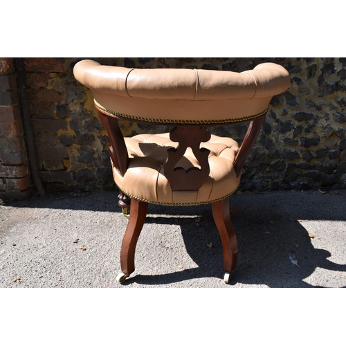 214 - An early Victorian mahogany and leather captain's desk chair, with buttoned tan leather backrest and... 