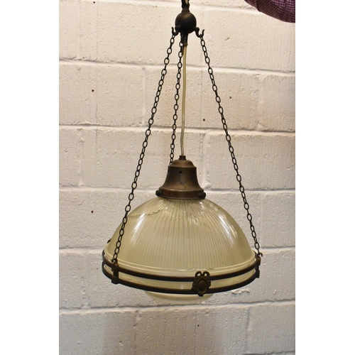 218 - A set of three brass mounted glass holophane pendant lights, each held on three chains joined to the... 