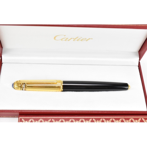 226 - Two Must De Cartier Stylo pens, one in gold plated mount numbered 005001, the other in gold colour a... 