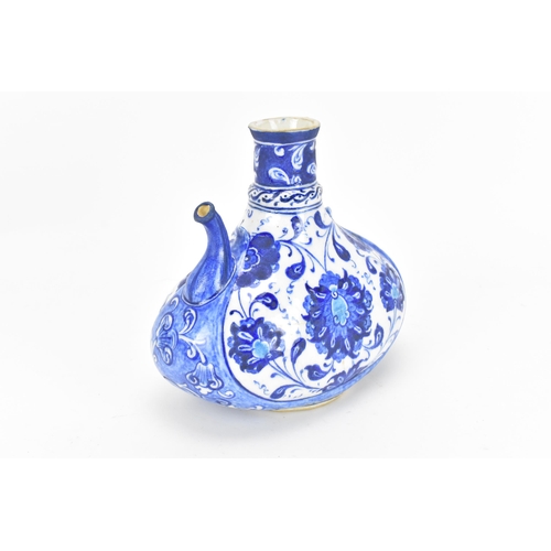 229 - A Turkish iznik style blue and white pottery water bottle, with foliate pattern and short spout, 17.... 