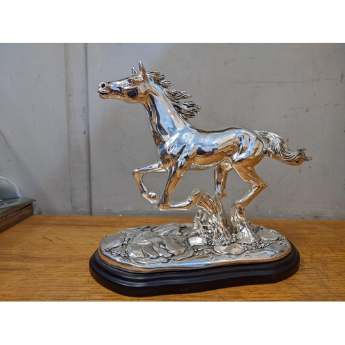 486 - An Italian silver plated model of a horse signed Marcello Giorgio on a naturalistic base and wooden ... 