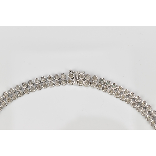 287 - An 18ct white gold and diamond necklace, designed with a double row of flat circular links centered ... 