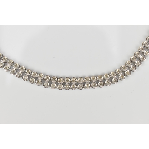 287 - An 18ct white gold and diamond necklace, designed with a double row of flat circular links centered ... 