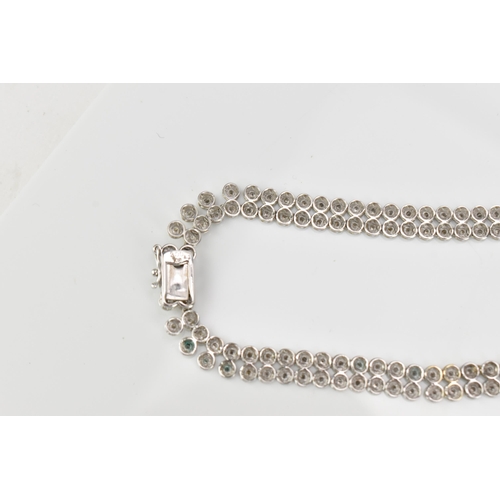 287 - An 18ct white gold and diamond necklace, designed with a double row of flat circular links centered ... 