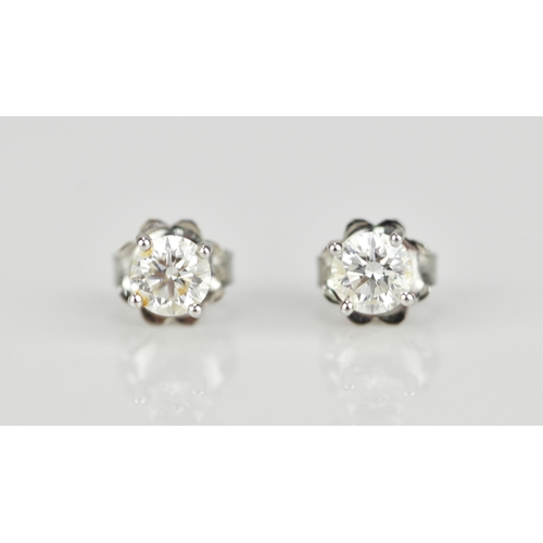 290 - A pair of solitaire diamond earrings, the brilliant cut stones approx 0.30 carat, in a four claw set... 