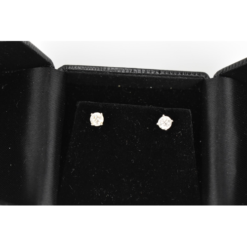 290 - A pair of solitaire diamond earrings, the brilliant cut stones approx 0.30 carat, in a four claw set... 