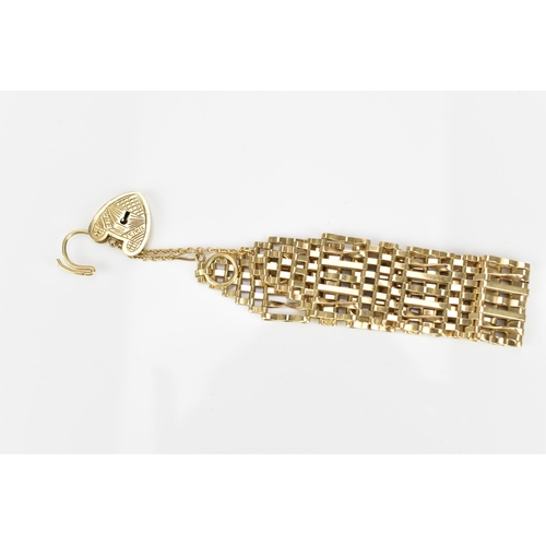 293 - A 9ct yellow gold thick gatelink bracelet, with engraved heart padlock clasp and safety chain, weigh... 