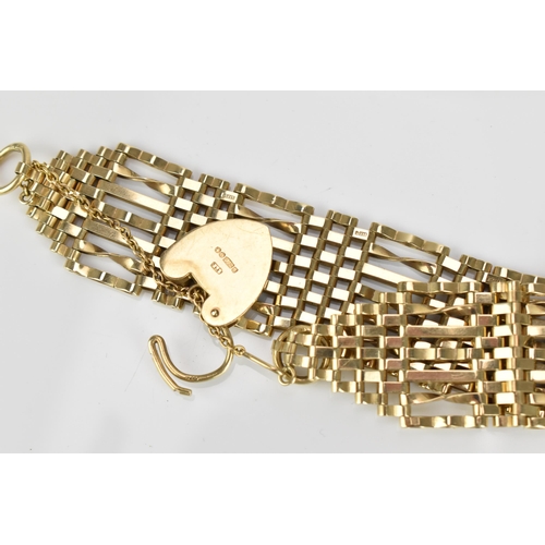 293 - A 9ct yellow gold thick gatelink bracelet, with engraved heart padlock clasp and safety chain, weigh... 