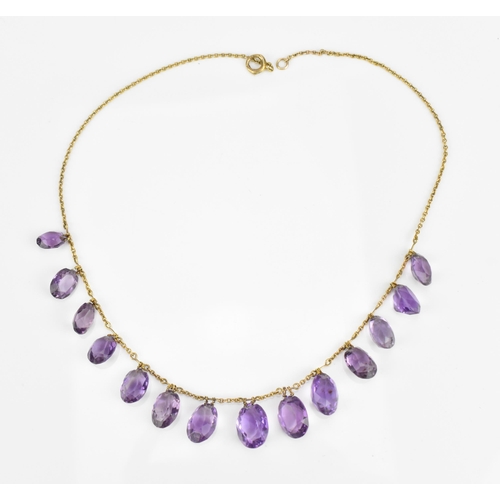 298 - A yellow metal and amethyst fringe necklace, set with graduated faceted oval cut amethyst drops, on ... 