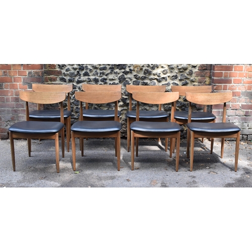 193 - A mid century extending teak dining table, d-ended, together with a set of eight dining chairs uphol... 