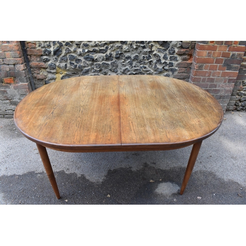 193 - A mid century extending teak dining table, d-ended, together with a set of eight dining chairs uphol... 