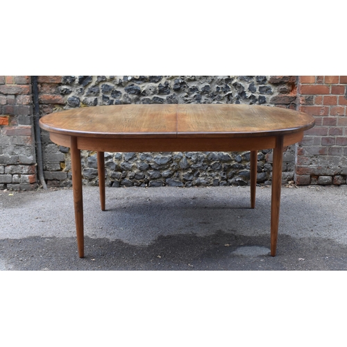 193 - A mid century extending teak dining table, d-ended, together with a set of eight dining chairs uphol... 