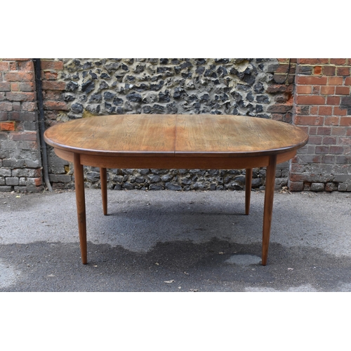 193 - A mid century extending teak dining table, d-ended, together with a set of eight dining chairs uphol... 