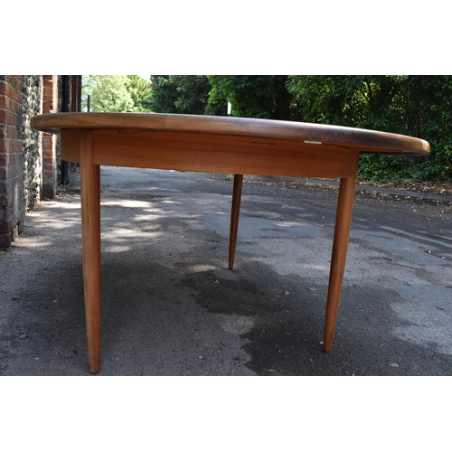 193 - A mid century extending teak dining table, d-ended, together with a set of eight dining chairs uphol... 