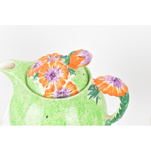 60A - A Clarice Cliff Bizarre 'Marguerite' pattern teapot, with three cups and saucers with flower handle,... 