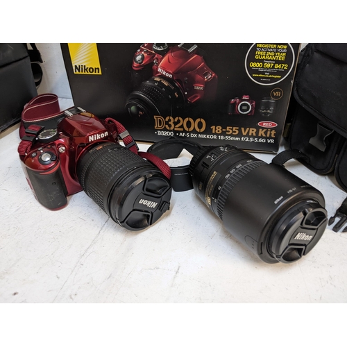 A Nikon D3200 red camera with 18:135m lens and a 55:300mm lens in