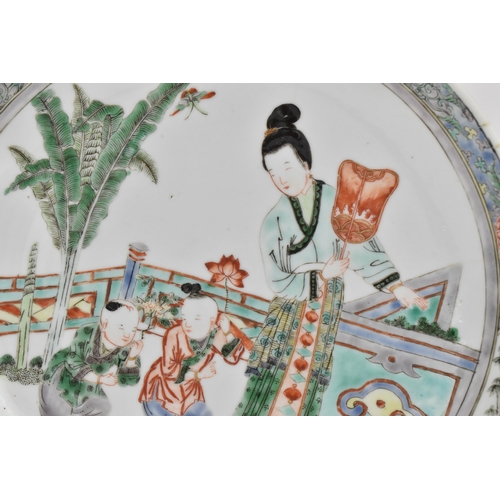 16 - A Chinese Famille Verte porcelain plate, 19th century, Qing dynasty, depicting a scene of two childr... 