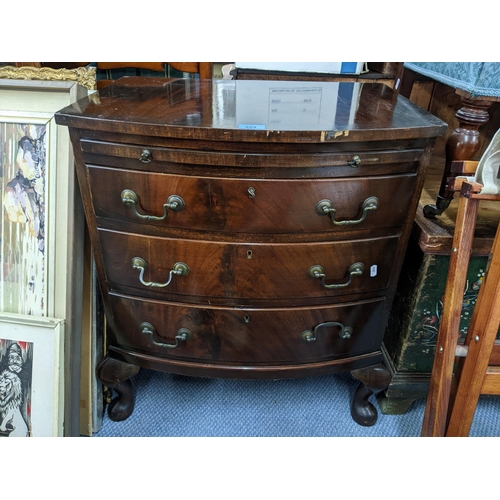 256 - A mid 20th century mahogany bow fronted small chest of three long drawers and a brush slide. 70.5x 6... 